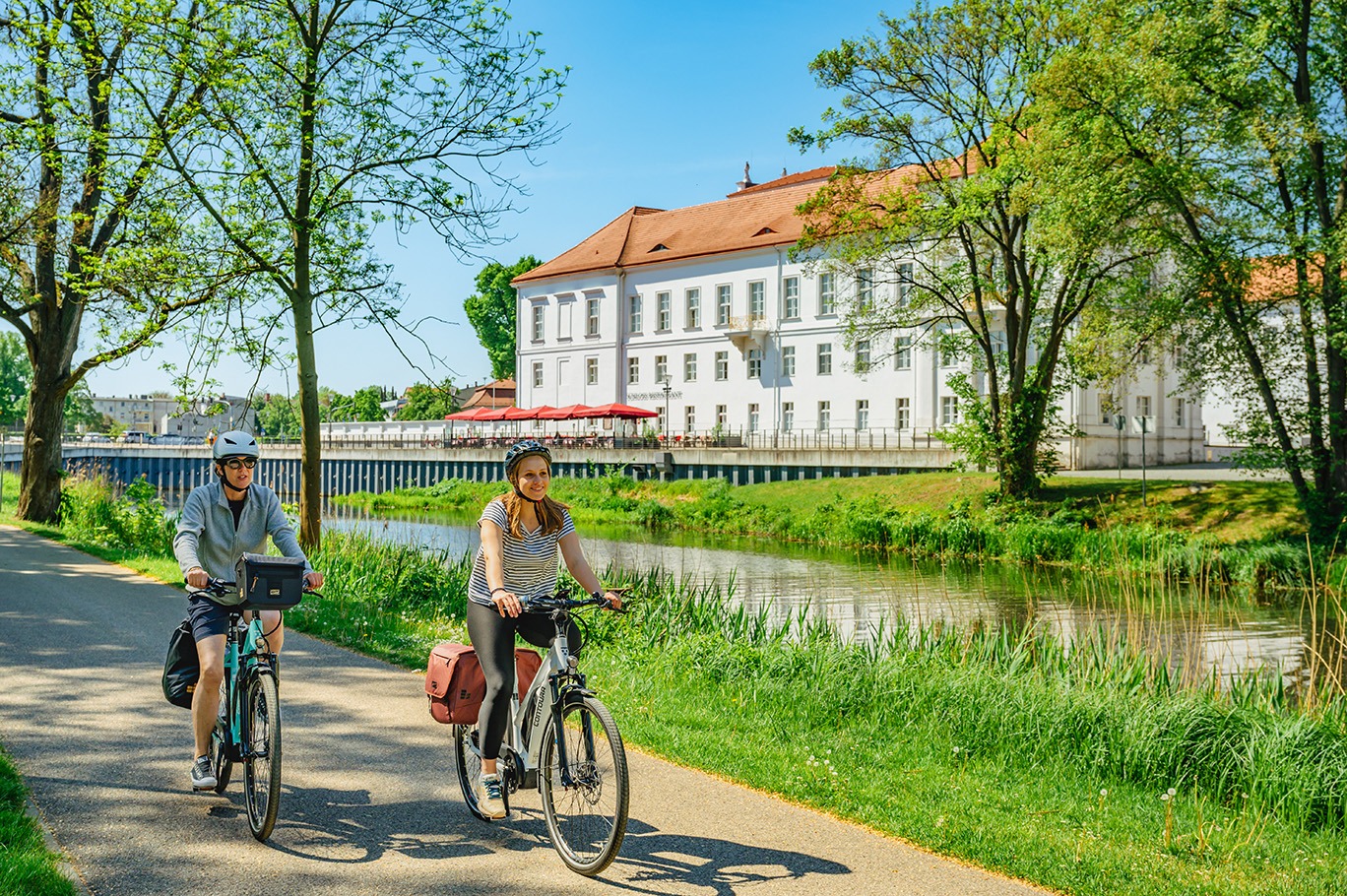 Zwei Frauen fahren vorbei an dem Schloss Oranienburg